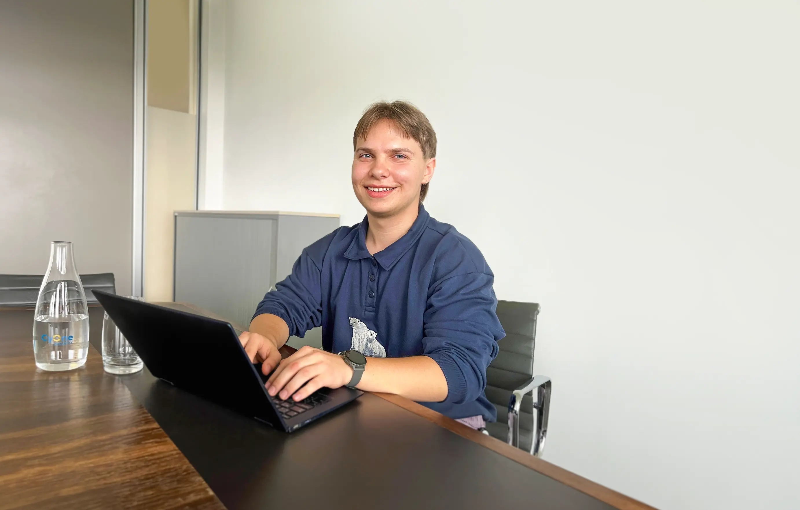 Der Lernende Aron sitzt an einem Tisch in einem Büro